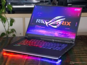 High-performance ASUS gaming laptop with RGB backlit keyboard and illuminated light bar on a wooden table