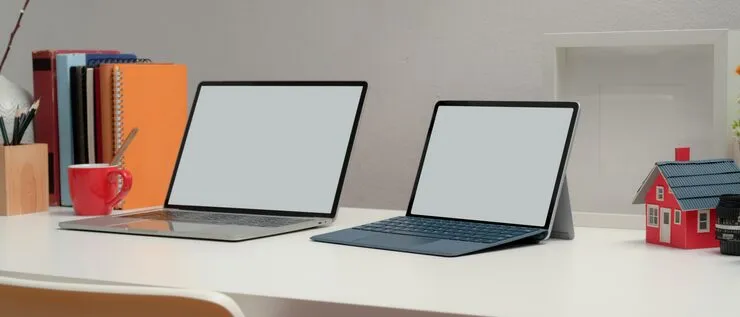 Cropped shot two blank screen laptop office desk with books decorations home office room 67155 9530